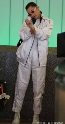 超模贝拉哈迪德从机场走出，一身银白色运动装，非常时髦有型！