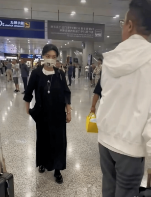 倪萍老婆走国际机场穿篮球衫流行时尚像小伙子，她全黑自然魅力婉约，太合得来